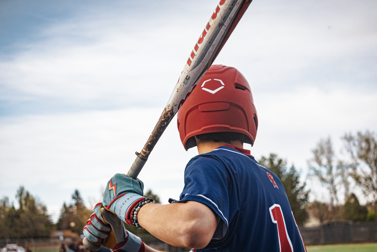 A baseball player raises his bat before swinging